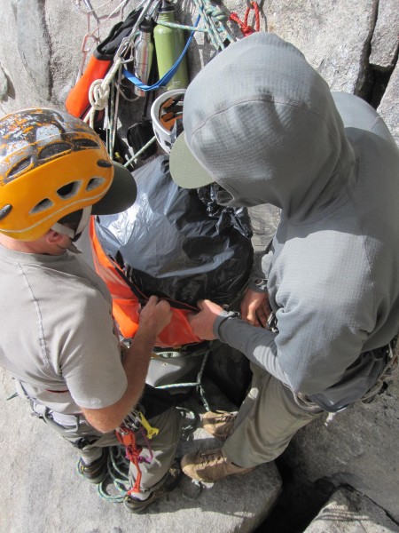 Stuffing the haul bag full of trash.